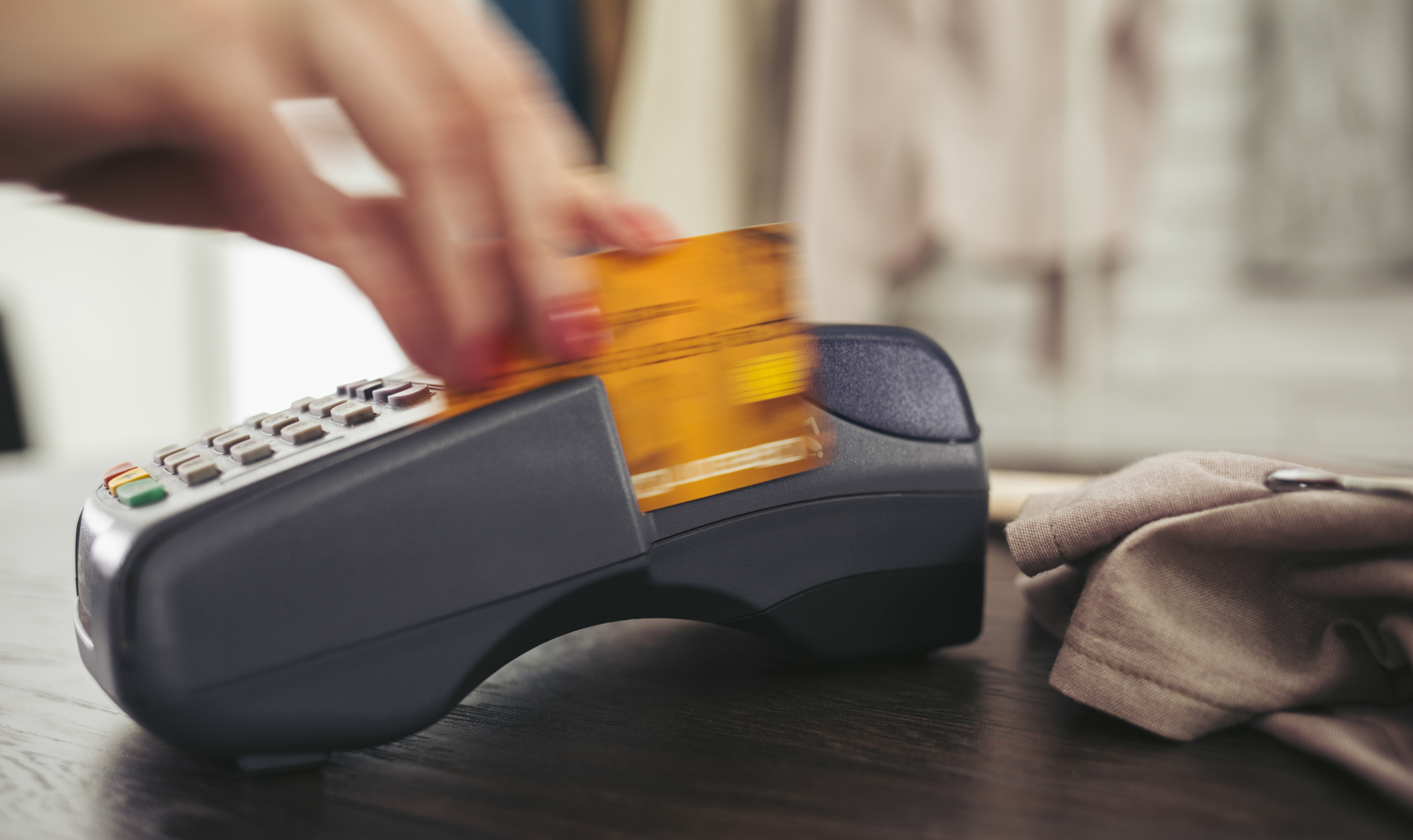 Woman swiping credit card through credit card reader